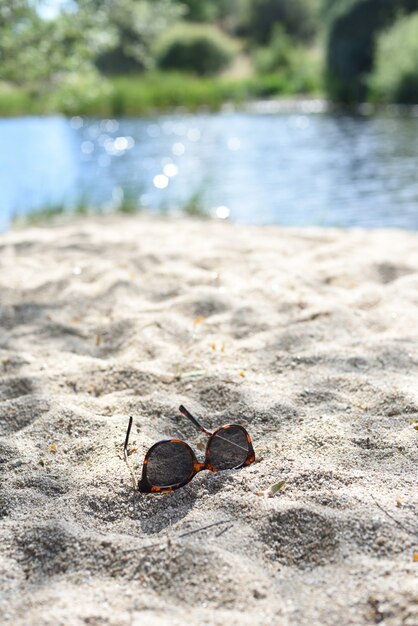 Zandstrand in de rivier en zonnebril