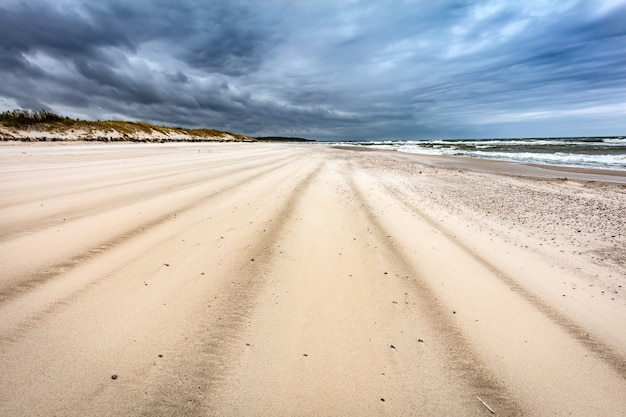 Zandstrand op een stormachtige dag aan zee.