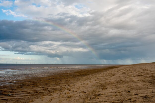 Zandstrand zee en bewolkte blauwe lucht in engeland in zonnige dag