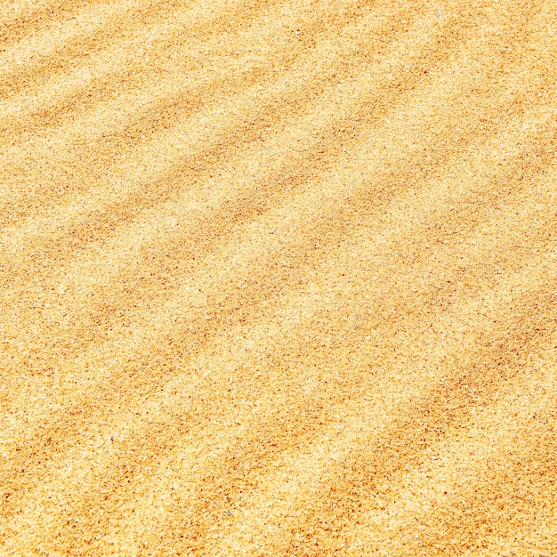 Zandtextuur op het strand met golven als natuurlijke tropische achtergrond