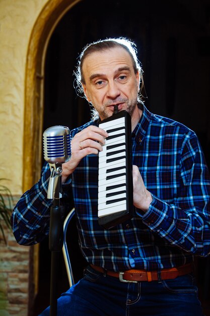 Foto zanger man met ouderwetse microfoon en piano