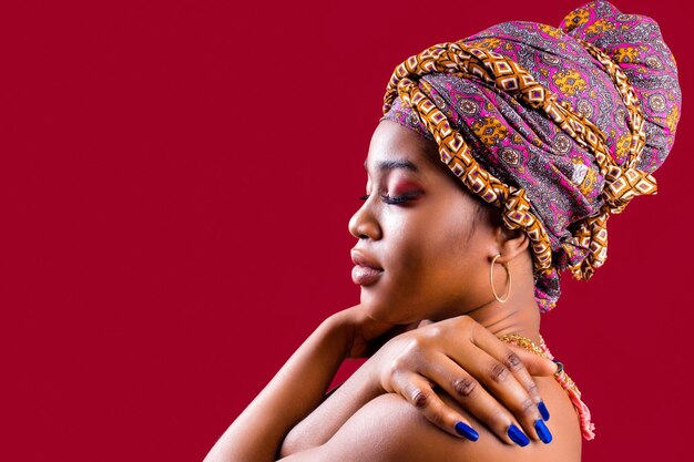 Занзибарская африканская женщина в тюрбане и макияже с голубыми ногтями