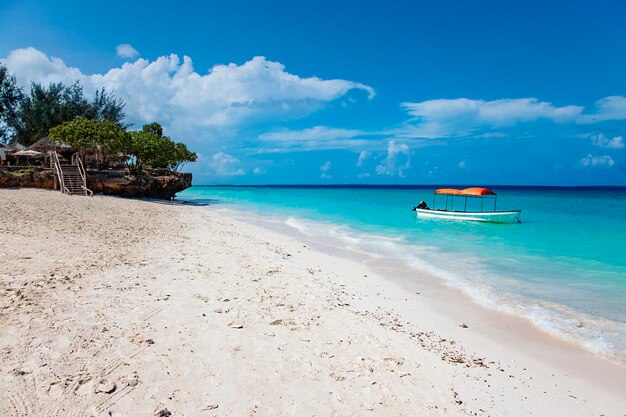 Zanzibar Nungwi beach with blue water and fishing boat