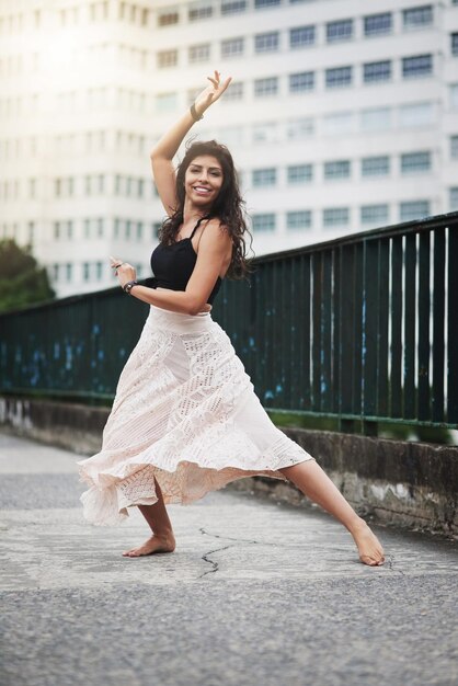 Ze beweegt met boeiende gratie Portret van een aantrekkelijke jonge vrouw die danst in de stad