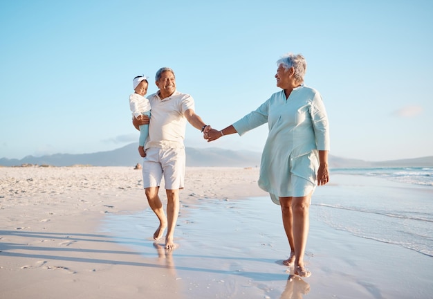 Ze geven onvoorwaardelijke liefde, vriendelijkheid, geduld, humor, troost en levenslessen. Shot van een senior koppel op het strand met hun schattige kleindochter.