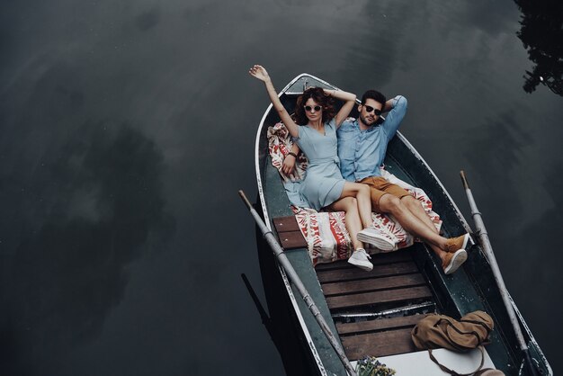 Ze hebben liefde gevonden. Bovenaanzicht van mooie jonge paar omarmen terwijl liggend in de boot