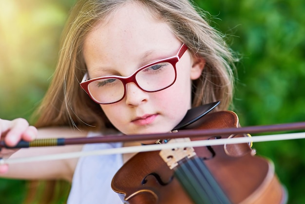 Ze heeft een geboren muzikaal talent Bijgesneden opname van een klein meisje dat buiten viool speelt