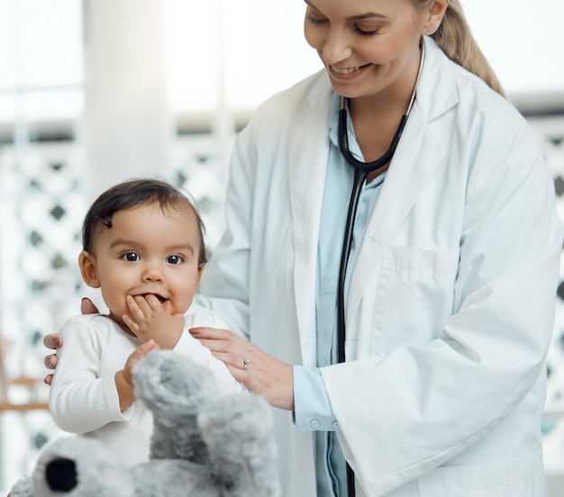 Ze heeft haar teddybeer om haar te troosten Foto van een kinderarts die een baby in een kliniek onderzoekt