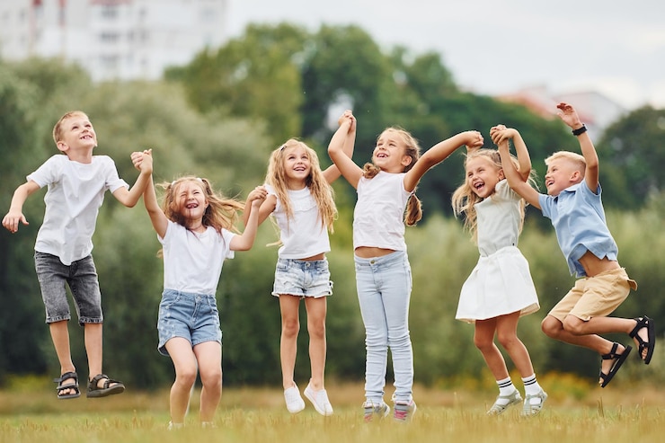 Foto ze houden elkaar bij de hand en springen. kinderen hebben plezier op het veld overdag.