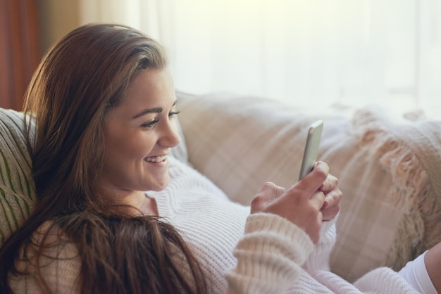 Ze is allemaal ingelogd op het weekend Shot van een mooie jonge vrouw die thuis sms't op haar mobiel