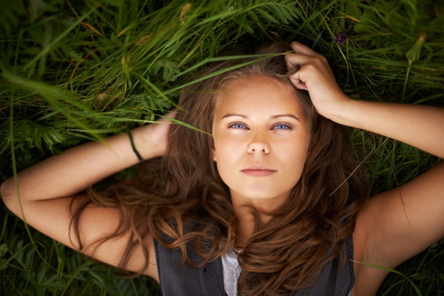 Foto ze is één met de natuur portret van een prachtige vrouw die buiten op haar rug ligt