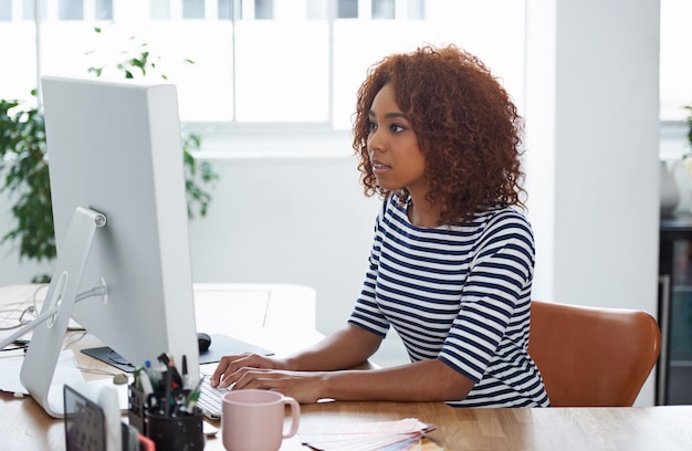 Ze is een specialist in het oplossen van problemen. Shot van een jonge vrouw aan het werk op een computer in een kantoor