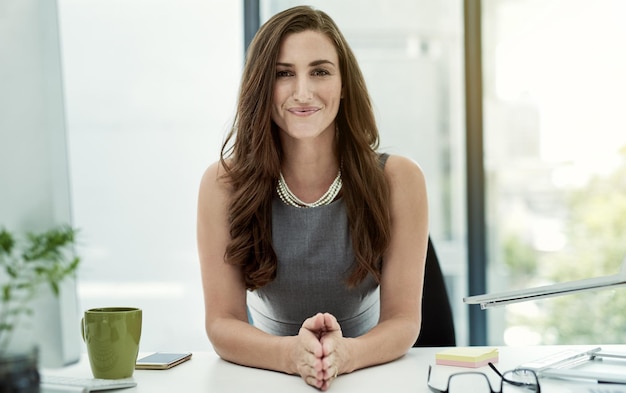 Ze is een zelfgemaakt succes Portret van een jonge zakenvrouw die aan haar bureau in een kantoor zit