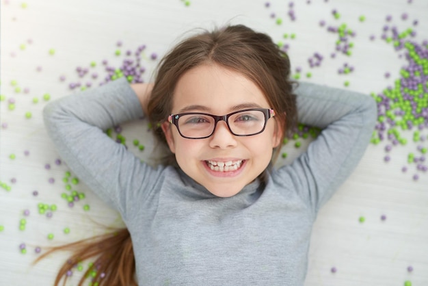 Ze is een zonnestraal Portret vanuit een hoog standpunt van een schattig klein meisje dat poseert met haar handen achter haar hoofd