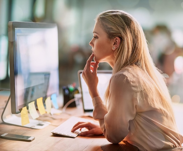 Ze is erg grondig in haar werk. Shot van een gefocuste jonge zakenvrouw die op een computer in een kantoor werkt