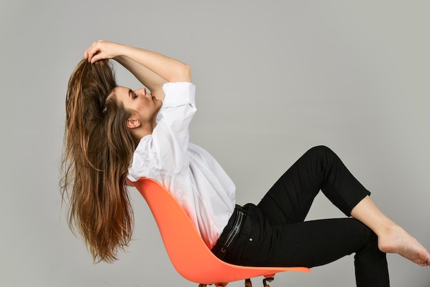 Ze kreeg een geweldige stijl. elegante fotomodel. meisje draagt kantooroverhemd en broek. haar casual stijl. stijlvolle zakenvrouw. sexy vrouw ontspannen op stoel. vrouwelijke schoonheid en mode. kapper schoonheidssalon.