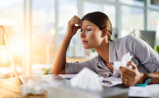 Ze probeert het hoofd te bieden, maar haar allergieën worden haar te veel Bijgesneden opname van een zakenvrouw die in haar kantoor werkt terwijl ze aan allergieën lijdt