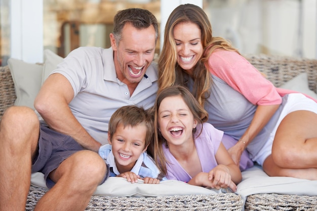 Ze weten hoe ze plezier moeten hebben portret van een gelukkig jong gezin van vier dat samen op het terras zit