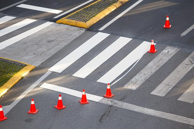 Zebra crossing in the process of being painted with masking tape and traffic cones on a city road no people