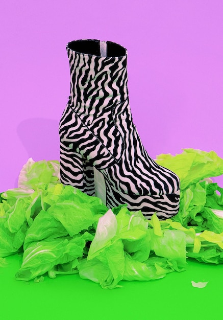 Zebra print fashion boots with fresh green salad background.\
healthy food, vegan, diet, calories, eco friendly minimal\
concept