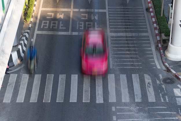 Zebrapad en auto, Bezige stadsstraat en auto in motieonduidelijk beeld op zebrapad