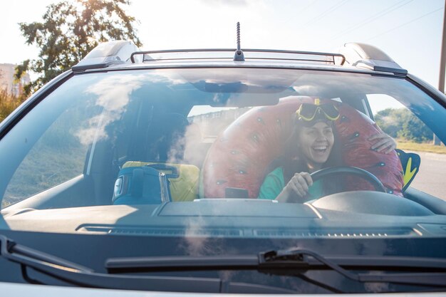 Zee auto reis reis lachende vrouw chauffeur in auto vol vakantie spullen