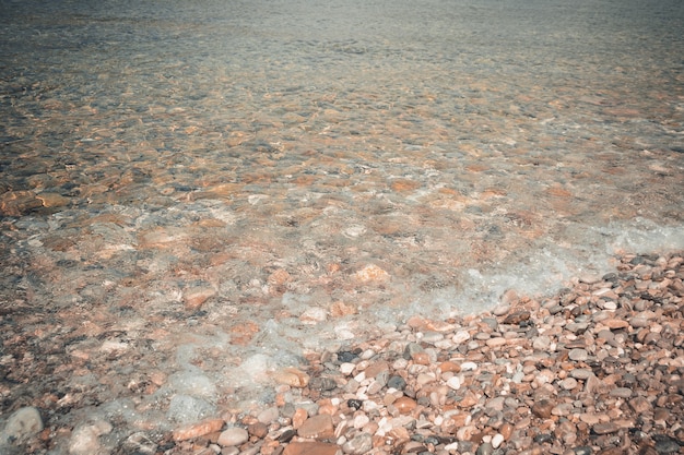 Zee kiezels en stenen onderwater textuur zeebodem door helder transparant blauw water natuurlijke ach...