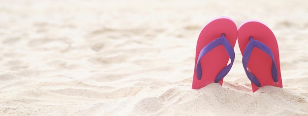 Zee op het strand Voetafdruk mensen op het zand en pantoffels van voeten in sandalen schoenen op strand zand achtergrond reizen vakantie concept