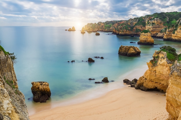 Zee strand bij zonsondergang. Bewolkte lucht. Portugal, Algarve, Lagos.