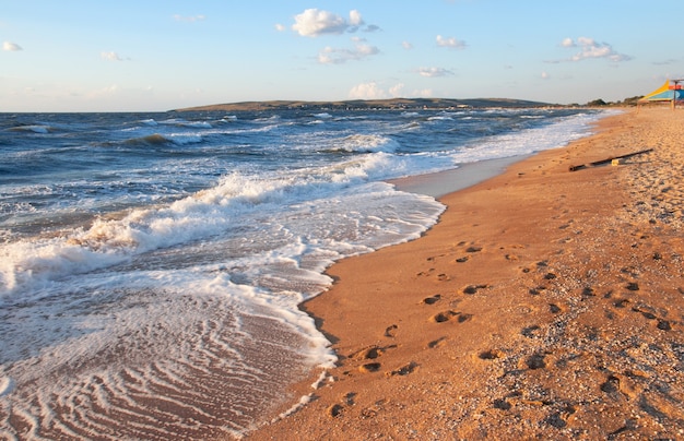 Zee surfgolf en zandstrand met voetafdrukken