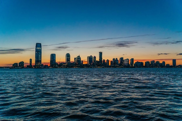 Zee tegen de stad bij zonsondergang