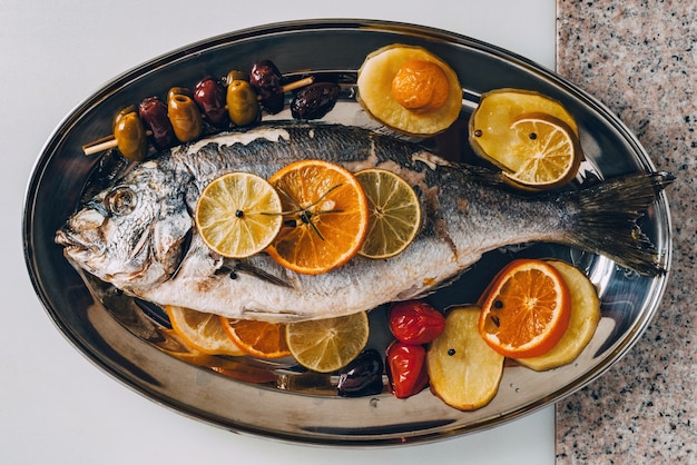 Zeebrasemvis op het bord gebakken met een smakelijke selectie tropisch fruit en groenten