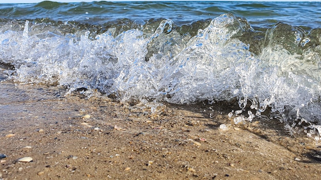 Zeegezicht. Azuurblauwe kleur van water, golven die op de kust schuimen.