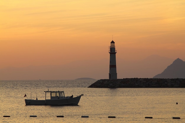 Zeegezicht bij zonneschijn vuurtoren en varen aan de kust Zeestad Turgutreis