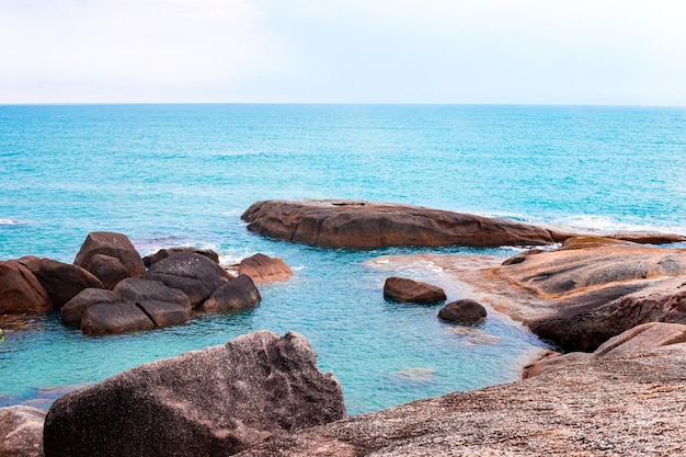 Zeegezicht Blauwe zee met rotsachtige kust op een tropisch eiland in Thailand