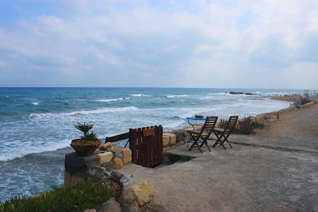 Zeegezicht in Kokkini Hani Kreta Griekenland Een tafel en twee stoelen op een verlaten strand Schilderachtig landschap met zeezicht in de avond