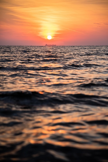 Zeegezicht Landschap Gouden zonsondergang in de zomer boven de Oostzee met een vrachtschip aan de horizon