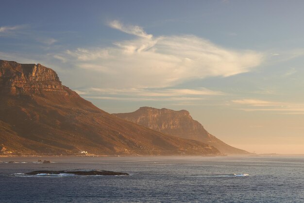 Zeegezicht landschap schilderachtig uitzicht op Hout Bay in Kaapstad Zuid-Afrika bij zonsondergang Blauwe oceaan en zee met bergen in de avond met copyspace Reizen naar het buitenland en overzee voor vakantie en vakantie