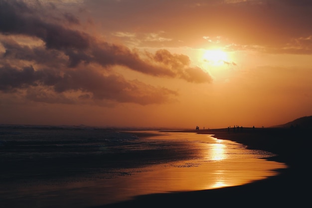 Zeegezicht met heldere hemel en golven op zonsondergang