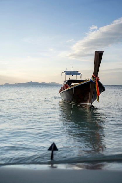 Zeegezicht op het prachtige strand van Thailand overdag met de houten boot op de voorgrond