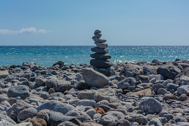 Zeegezicht Piramide van stenen op een rotsachtige kust tegen de zee