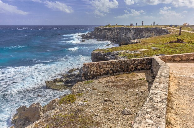 Zeegezicht van rotsachtige kustlijn met klif met uitzicht op de zee bij isla mujeres in mexico