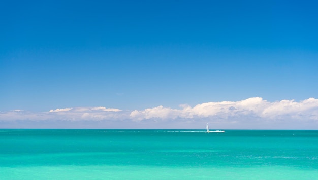 zeegezicht zomer natuur met jacht aan horizon zeegezicht zomer natuur op vakantie zeegezicht zomer natuur met turquoise water foto van zeegezicht zomer natuur