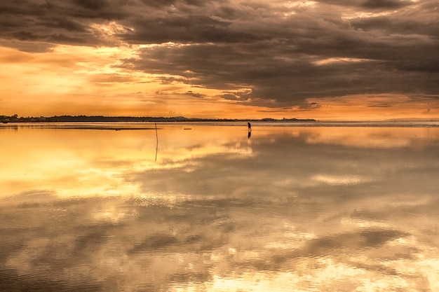 Zeegezichtmening van zonsondergang op het lange strand met reflex op het zandstrand