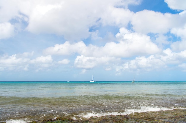 Zeegolf, strand en blauwe bewolkte hemel. Natuur, water, oceaan, zomerlandschap. Reizen, ontspannen vakantie. Tropisch eiland of kust. Reislust, avontuur, ontdekking.