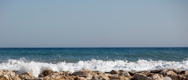 Zeegolven die tegen de rotsen beuken