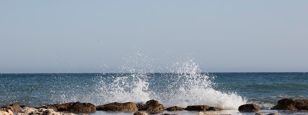 Zeegolven die tegen de rotsen beuken