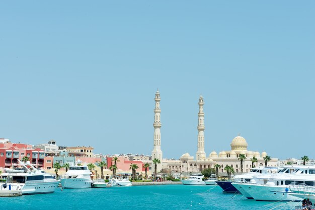 Zeehaven met stenen stadsdijk met geparkeerde speedboten en de moskee van Hurghada