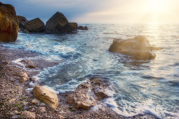 Zeekust met rotsen, blauw water en zonnige lucht, natuurlijke seizoensgebonden zomerachtergrond