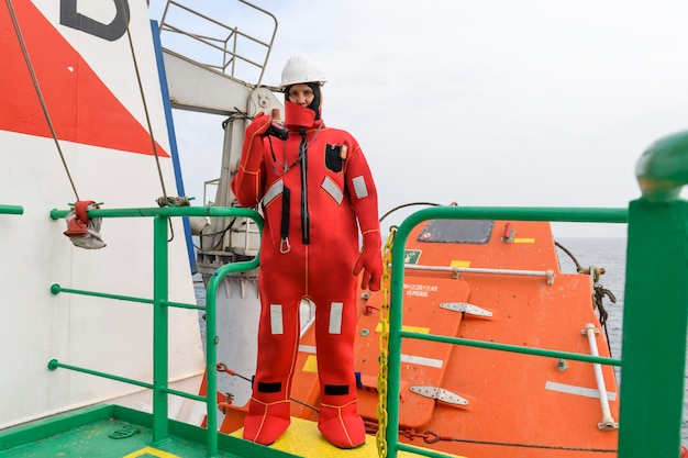 Foto zeeman met een onderdompelingspak op het verzamelstation verlaat de scheepsboor vrije valboot vrachtschip